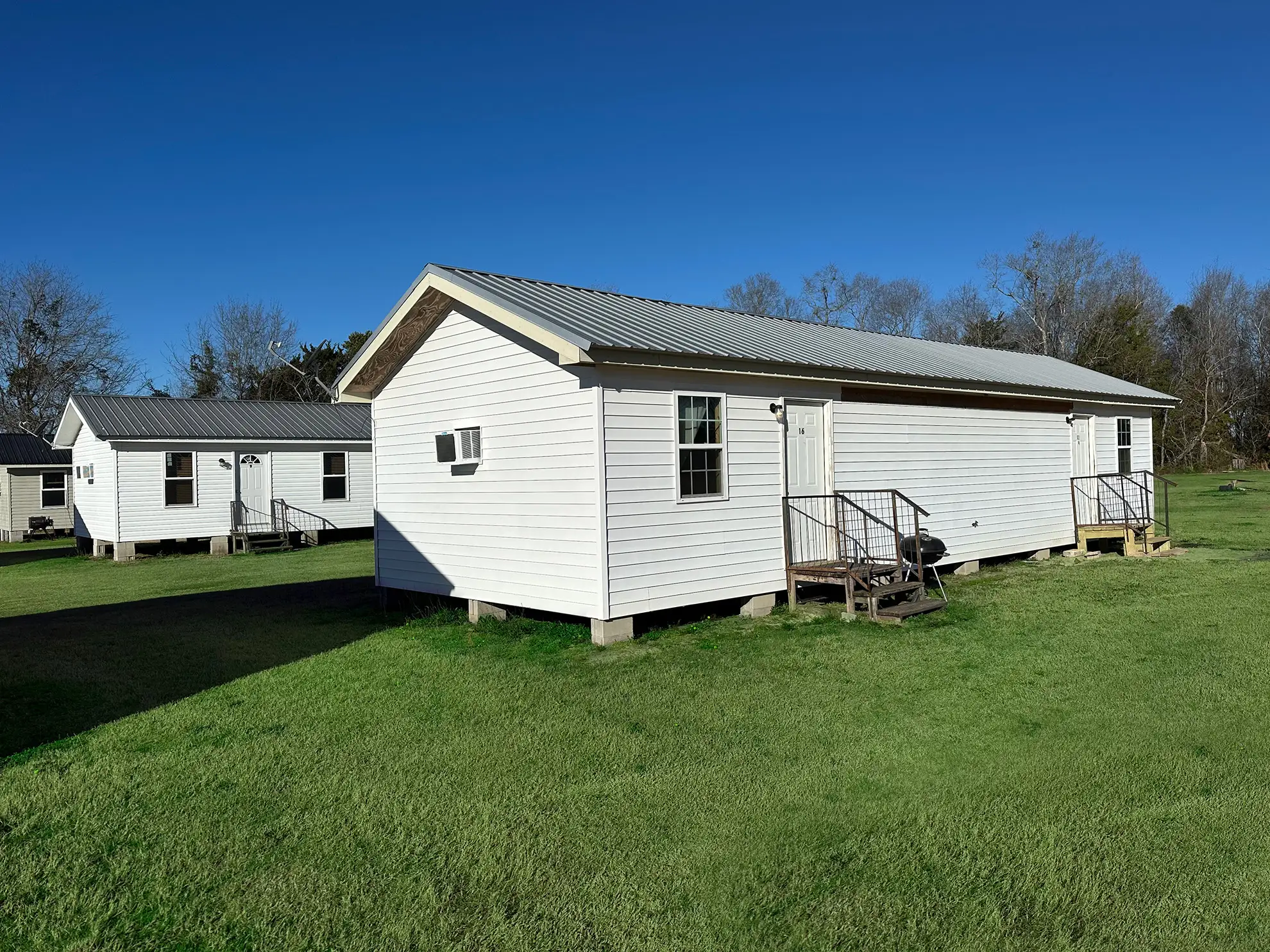 Cabins and RV sites on the green grounds of Vogtle Ranch RV & Mobile Home Park