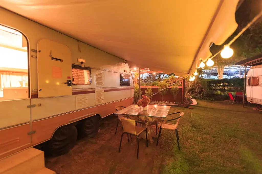 RV site at night with ambient lighting and outdoor dining setup