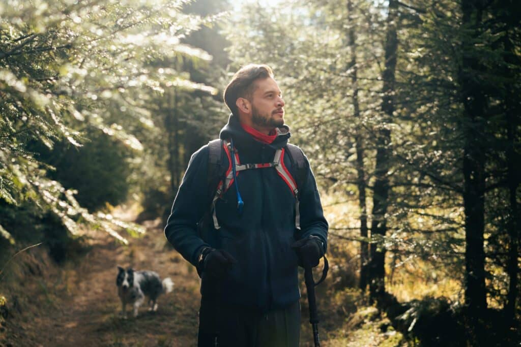Image of man and his dog exploring the forest.